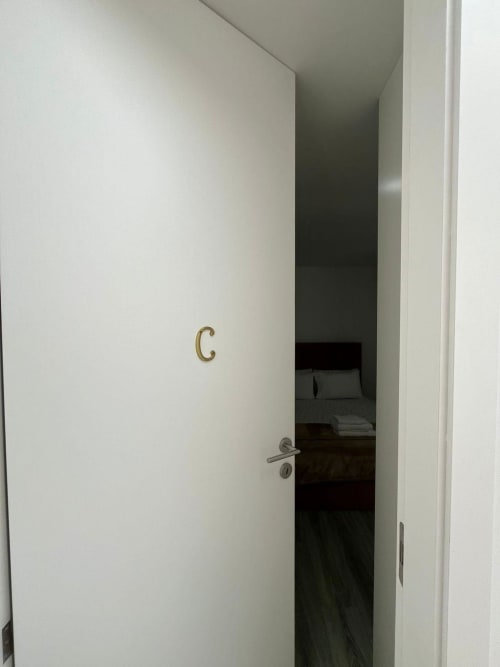 White door labeled C leading to Suite C bedroom at Casa Augusta hostel in Braga, Portugal