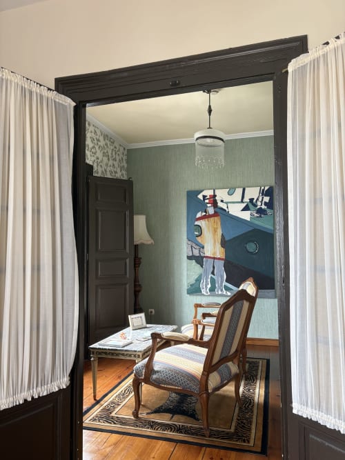 Suite elegante en Hotel Palacio La Casona de Cerrazo con silla de madera, paredes verdes y arte náutico cerca de puerta negra