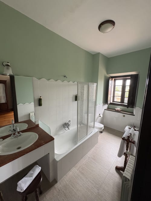 Baño espacioso en Hotel Palacio La Casona de Cerrazo con doble lavabo, ducha amplia y vistas a la montaña