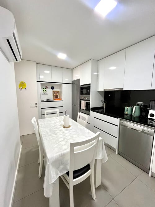 Modern white kitchen with dining table at Casa Augusta hostel Suite C in Braga, Portugal