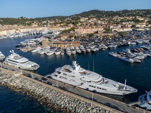 Yacht de luxe amarré au port de Cavalaire-sur-Mer avec village méditerranéen en arrière-plan