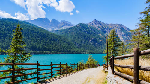 Lago alpino turchese con vette montane e bosco a Camere d'Aria, Locana Italia