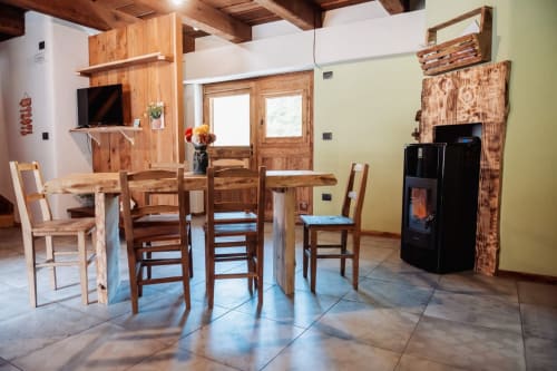 Area ristorazione rustica a Borgo Maira Village a Prazzo con tavolo in legno, sedie e arredamento tradizionale di rifugio di montagna italiano