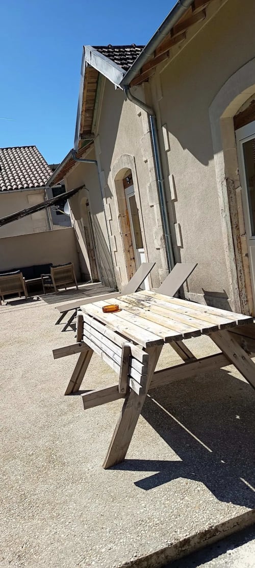 Table de pique-nique en bois sur la terrasse gravillonnée du gîte Domaine Alga à Bourg-Charente, France