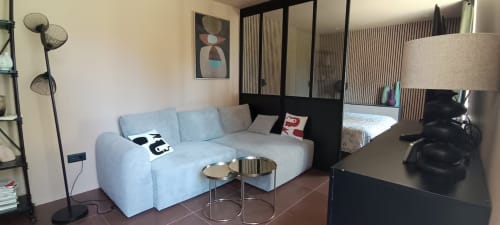 Chambre moderne à Domaine Alga avec canapé bleu clair, bureau et vue sur le jardin à Bourg-Charente