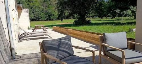 Patio avec vue sur le jardin du cottage La Garçonnière, Domaine Alga, avec chaises longues et bacs de culture surélevés