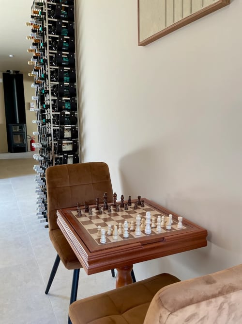 Jeu d'échecs en bois sur fauteuil en cuir à la Domaine Alga en Bourg-Charente, équipement audio visible