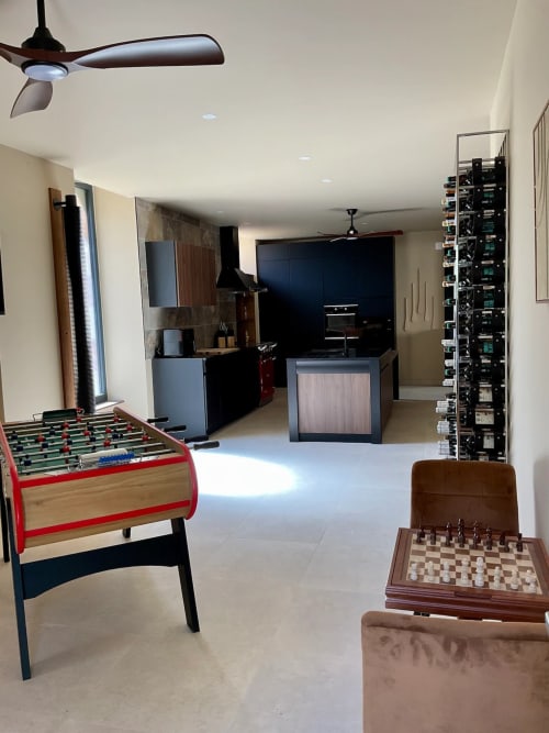 Salle de jeux du gîte Domaine Alga à Bourg-Charente avec baby-foot, échecs et cuisine moderne.