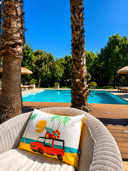Chaise tressée avec coussin aux motifs marins surplombant la piscine turquoise de La Maison D'ambrine, Chamaret