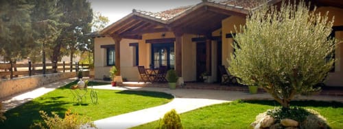 La Senda del Duraton exterior con edificio de terracota, jardín cuidado, olivo y porche de madera en Sebúlcor