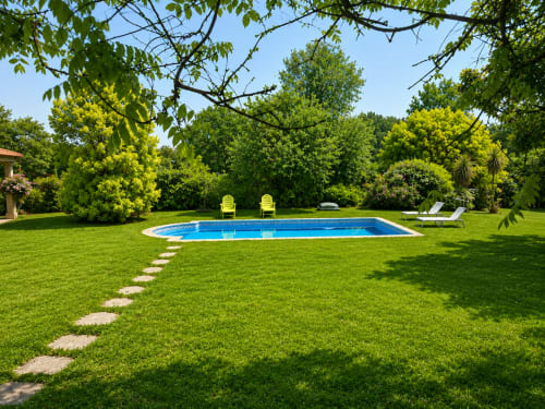 Lujosa casa de campo junto al río en Tomiño con piscina rectangular, césped verde exuberante, tumbonas amarillas y árboles maduros