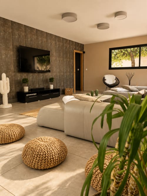Chambre moderne à La Maison D'ambrine avec mobilier beige, mur texturé et lumière naturelle
