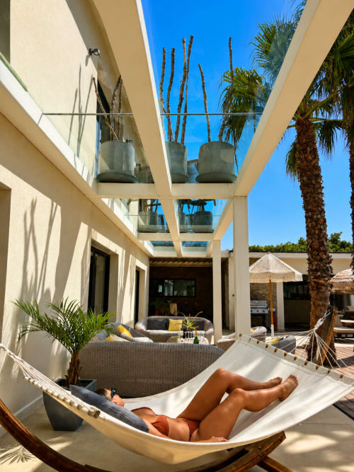 Personne se relaxant dans un hamac à la Maison D'ambrine à Chamaret, avec terrasse moderne et palmiers
