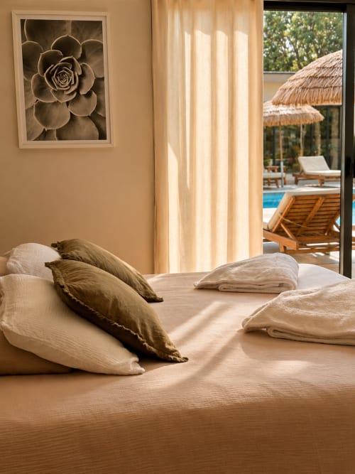 Chambre de luxe à La Maison D'ambrine avec vue sur la piscine, literie neutre et art de succulentes à Chamaret