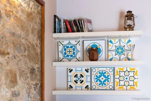 White floating shelves with decorative blue and yellow Portuguese tiles, books, and brass lantern in Quinta Boa Vida room
