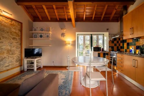 Modern kitchen and living area in Hidden Jewel Villa at Quinta Boa Vida, Alcobaça with wooden beams and garden view