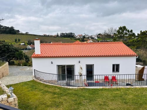 Modern white villa with red tile roof at Quinta Boa Vida, Portugal, featuring garden views and terraced patio area