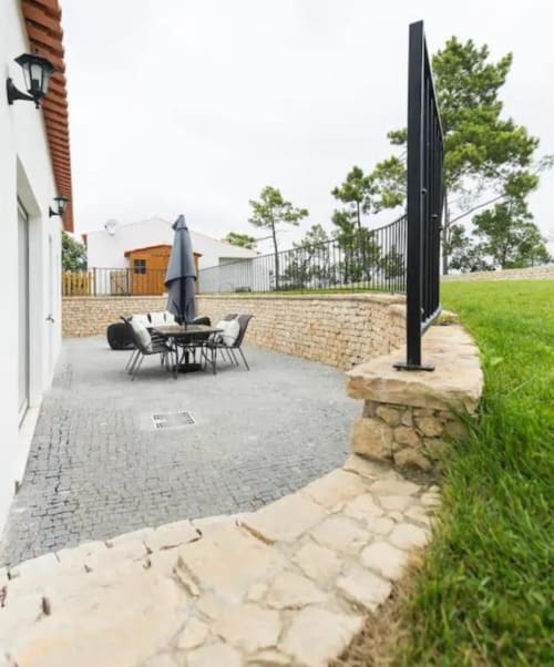 Quinta Boa Vida patio garden view with dining area, umbrella, and green lawn in Alcobaça