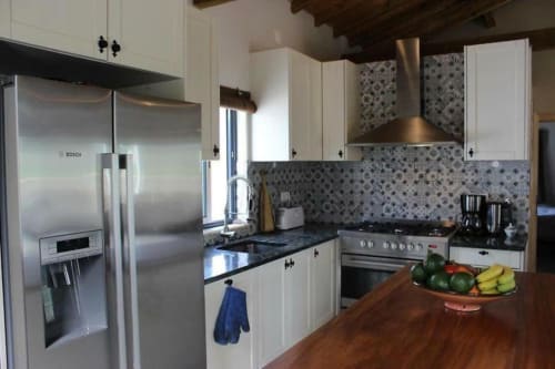 Modern kitchen with stainless steel appliances, white cabinets, and patterned backtile at Quinta Boa Vida villa in Alcobaça