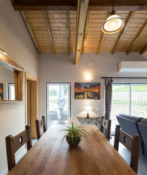 Dining area in Master Villa at Quinta Boa Vida, Alcobaça with wooden table, beamed ceiling, and garden views
