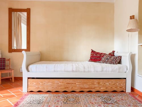 Quarto luminoso na Quinta da Mata de Baixo com cama de trenó branca, cama auxiliar em madeira, azulejos de barro e espelho com vista para o jardim