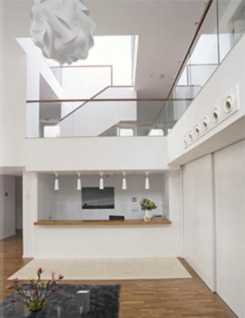 Interior minimalista moderno del Hostal Dona Blanca con tragaluz, paredes blancas, pisos de madera y cocina contemporánea