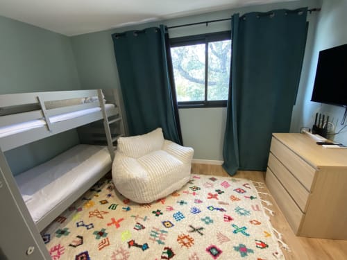 Chambre d'enfants moderne à la villa Casa di Sadrea à Lecci avec lits superposés, fauteuil, TV et tapis coloré