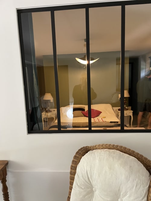 Chambre moderne avec baie vitrée aux Pratges BnB à Figeac, lit avec coussin rouge et lampe