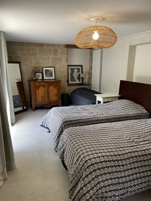 Spacieuse chambre de loft aux Chambres d'hôtes Les Pratges à Figeac avec deux lits, mobilier en bois et suspension tissée