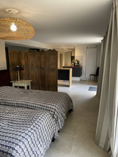 Chambre loft moderne aux Pratges B&B à Figeac avec lits jumeaux, armoire en bois et coin cuisine