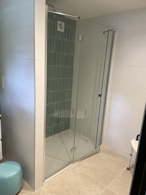 Douche spacieuse aux parois vitrées et carrelage vert dans la salle de bain de la maison d'hôtes Les Pratges, Figeac