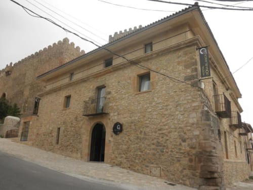 Hostal Doña Blanca, edificio histórico de piedra en España con arquitectura tradicional y balcones de hierro forjado