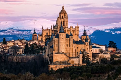 El emblemático castillo de Alcázar de Segovia con montañas nevadas, cerca del hotel La Senda del Duratón en Sebúlcor