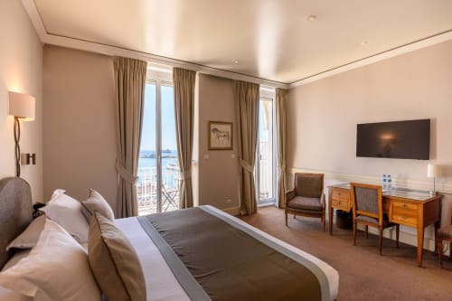 Suite di lusso all'Hotel Splendid Cannes con balcone vista mare, letto queen, TV schermo piatto e servizi moderni