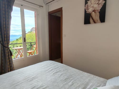 Chambre de l'hôtel Allegria à Bajardo avec balcon vue mer, lit blanc et paysage côtier