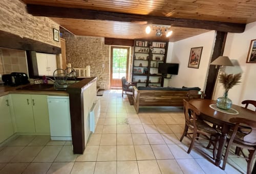 Cuisine ouverte et salle à manger du gîte La Vieille Maison à La Vieille Ferme de La Doinie, Saint-Geniès, avec poutres