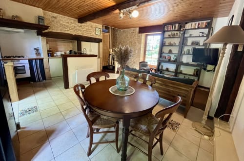 Séjour et salle à manger ouverts à La Vieille Maison, Saint-Geniès, avec table ronde en bois, cuisine et bibliothèques
