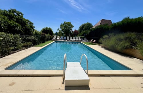 Piscine privée avec transats au Gîte La Vieille Ferme à Saint-Geniès, entourée de jardins verdoyants