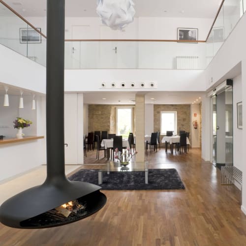Elegante recepción del Hostal Dona Blanca con chimenea, comedor y diseño contemporáneo
