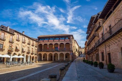 Plaza medieval de Sigüenza con edificios históricos de piedra y arquitectura porticada cerca del Hostal Doña Blanca