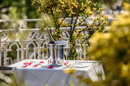 Elegante servizio di champagne sulla terrazza dell'Hotel Splendid Cannes con fiori gialli e ringhiera in ferro decorativo