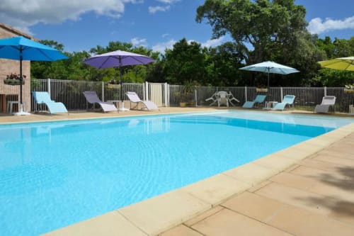 Piscine scintillante avec transats et parasols à l'hôtel RJD Conciergerie Côte d'Azur à Sainte-Lucie-de-Porto-Vecchio