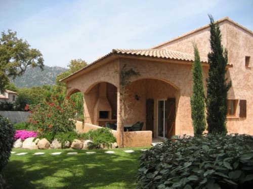Villa Casa Callista avec façade en terre cuite, portique en arches, jardin paysagé et cyprès