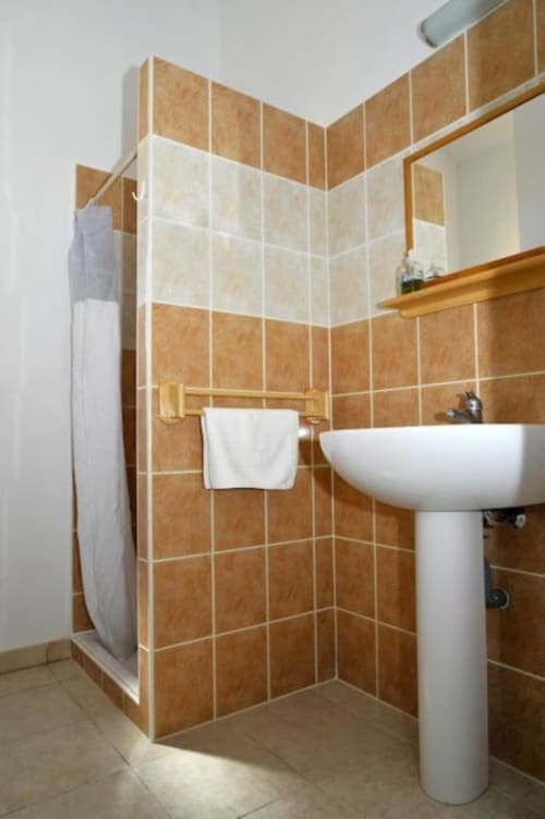 Salle de bain moderne avec carrelage terre cuite, lavabo sur colonne blanc et cabine de douche à la villa Casa Callista Est, RJD