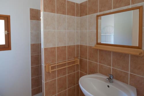 Salle de bain moderne de la villa Casa Callista West à RJD Conciergerie Côte d'Azur avec murs carrelés beige, lavabo, miroir et serviettes