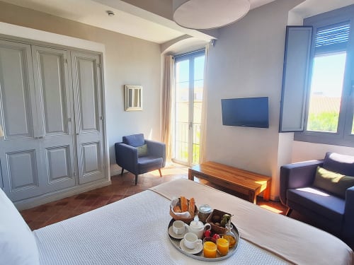 Habitació doble moderna a l'Hotel Casa Calella a Palafrugell amb vistes al jardí, llit, zona de sala d'estar, TV i accés a terrassa