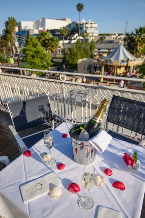 Cena romantica in terrazza all'Hotel Splendid Cannes con champagne, petali di rosa e vista sul carnevale