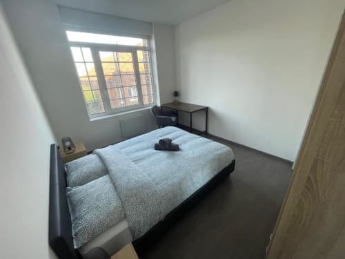 Chambre lumineuse aux Business Apparts Caudry avec vue sur la ville, lit queen-size, bureau de travail et mobilier moderne