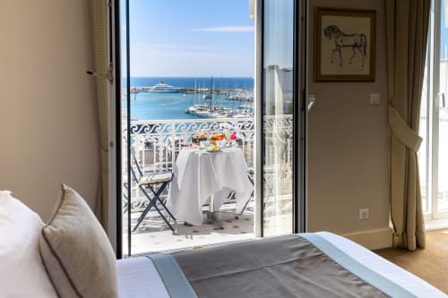Camera lussuosa con vista mare all'Hotel Splendid Cannes, balcone privato affacciato sulla marina e le barche a vela
