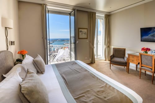 Camera di lusso presso l'Hotel Splendid Cannes con balcone affacciato sul mare della marina mediterranea e le barche a vela